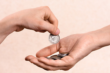 Image showing hand putting coins in the palm of another person