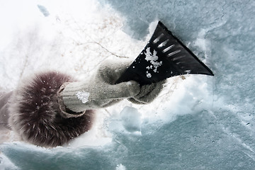 Image showing hand with scraper cleaning window of car from the snow