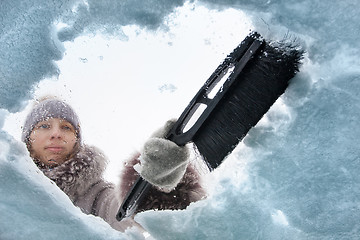 Image showing woman cleaning window of car from the snow with a brush