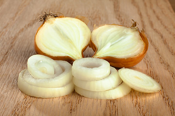 Image showing fresh sliced onions on wooden background