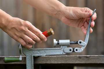 Image showing hands reloading cartridge by shotgun shell reloader