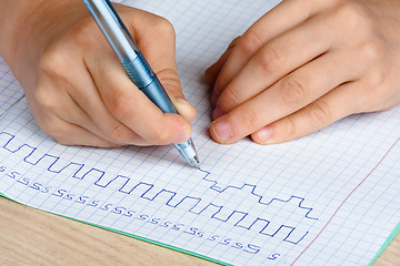 Image showing hands of child writing in notebook