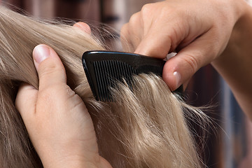 Image showing hands of woman combing hair her daughter