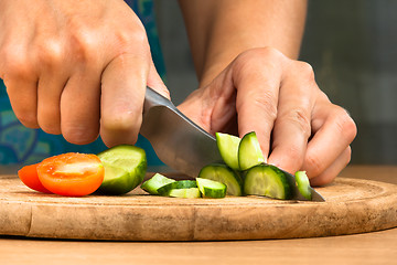 Image showing hands chopping cucumber for salad
