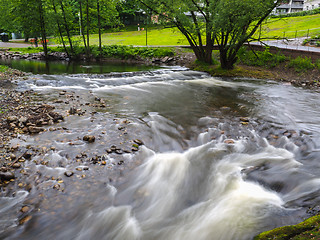 Image showing Strong current in river passing around rocks with long exposure