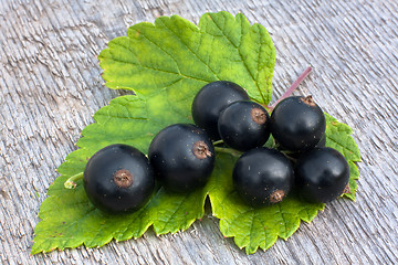 Image showing berries of black currant on wooden background, closeup