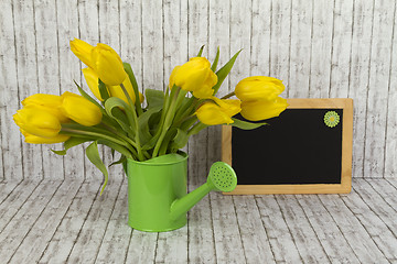 Image showing Beautiful flowers and blank blackboard