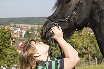 Image showing Beautiful young woman with her black horse 