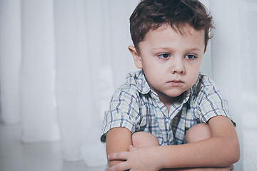 Image showing Portrait of sad little boy sitting near the window