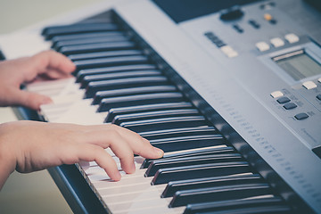 Image showing Little girl playing synthesizer