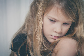 Image showing Portrait of sad little girl sitting near the window