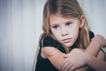 Image showing Portrait of sad little girl sitting near the window