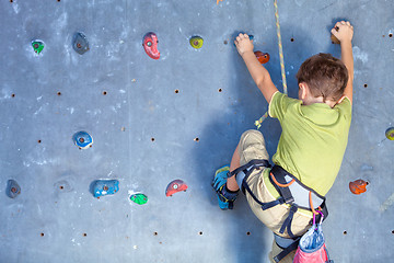 Image showing little boy climbing a rock wall