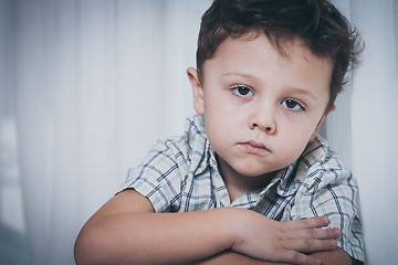 Image showing Portrait of sad little boy sitting near the window