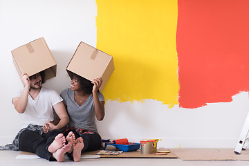 Image showing young multiethnic couple playing with cardboard boxes