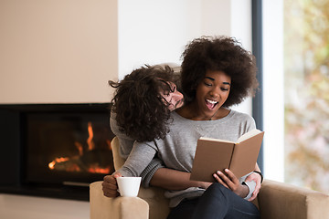 Image showing multiethnic couple hugging in front of fireplace