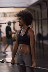 Image showing black woman lifting empty bar