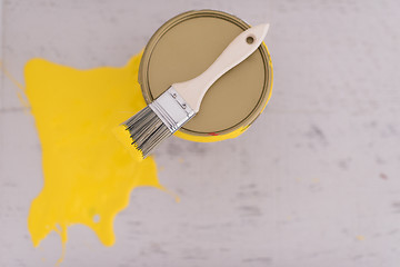 Image showing Yellow paint tin can with brush on top