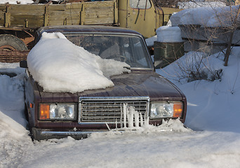 Image showing Snow-covered car in the parking lot urban scene after a snowstorm