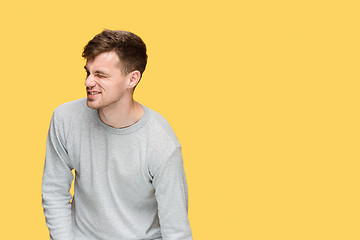 Image showing Tired businessman or The serious young man over yellow studio background with pain