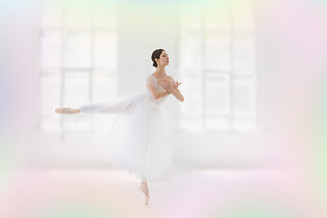 Image showing Young and incredibly beautiful ballerina is posing and dancing in a white studio