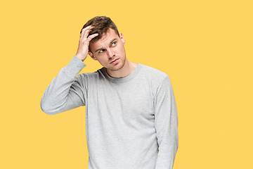 Image showing Tired businessman or The serious young man over yellow studio background with headache emotions