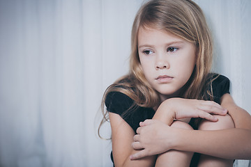 Image showing Portrait of sad little girl sitting near the window