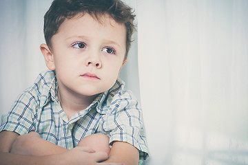 Image showing Portrait of sad little boy sitting near the window