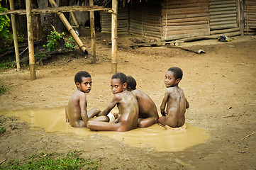 Image showing Four boys in mud