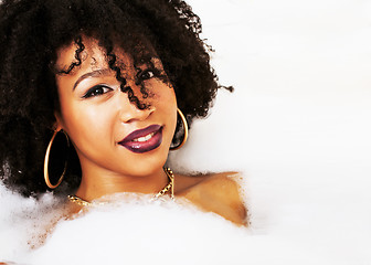 Image showing young afro-american teen girl laying in bath with foam, wearing 