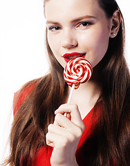 Image showing young pretty brunette girl with red candy posing on white background isolated
