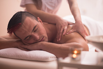 Image showing young man having a back massage