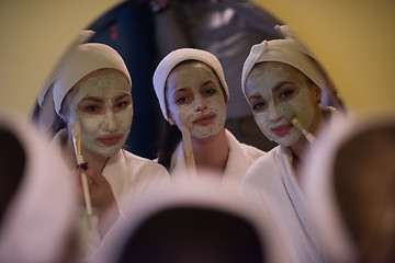 Image showing women putting face masks in the bathroom