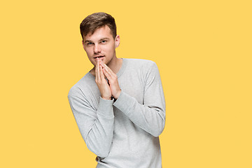 Image showing The young serious man looking cautiously and Speaking secret