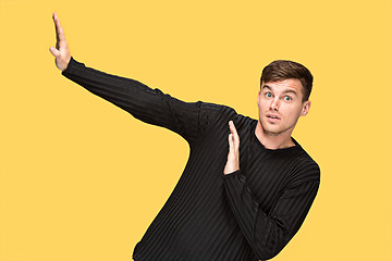 Image showing The young man pointing to something and looking at camera