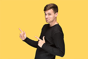 Image showing The young man pointing to something and looking at camera