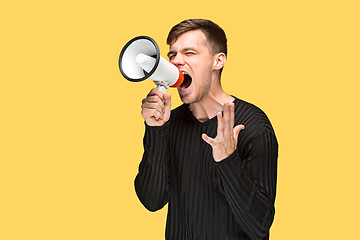 Image showing The young man holding a megaphone