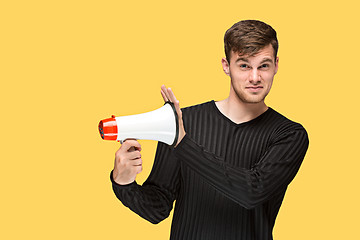 Image showing The young man holding a megaphone