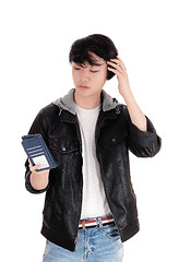 Image showing Asian teenager looking at his cellphone.