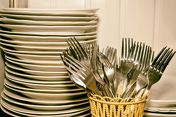 Image showing A stack of washed dishes and forks in the kitchen