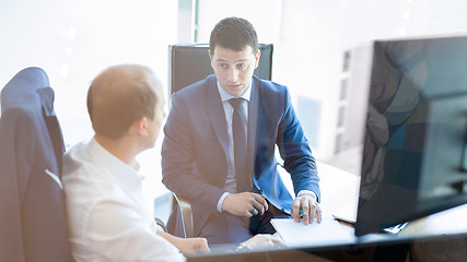 Image showing Two businessmen discussing a bisiness problem at meeting in trading office.