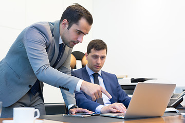 Image showing Business team remotely solving a problem at business meeting using laptop computer and touchpad.