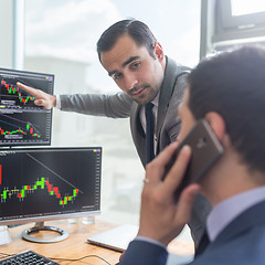 Image showing Stock brokers looking at computer screens, trading online.