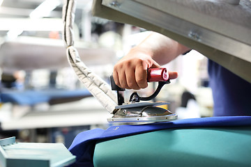 Image showing Presser in sewing clothes pressed. 