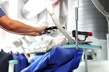 Image showing Clothing industry. Ironing steam. Presser in sewing clothes pressed. 