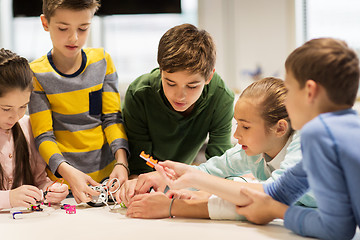 Image showing happy children building robots at robotics school