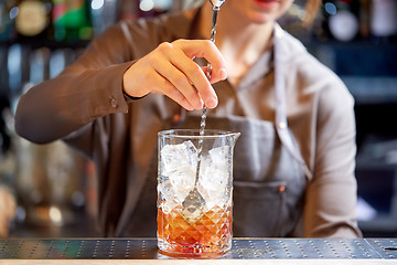 Image showing bartender with cocktail stirrer and glass at bar