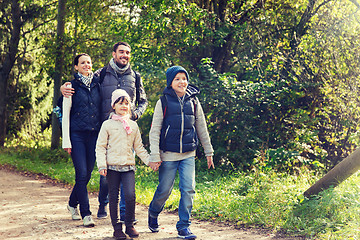 Image showing happy family with backpacks hiking in woods