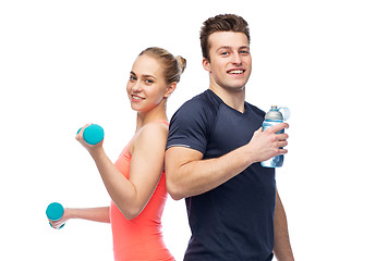 Image showing sportive man and woman with dumbbell and water