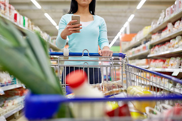 Image showing woman with smartphone buying food at supermarket